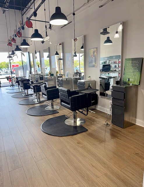 Interior of Fusion Salon in Jacksonville featuring modern hair styling stations and expert Aveda color and extension services.