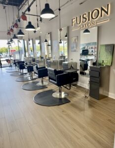 Bright, modern interior view of the styling stations and custom branding at Fusion Salon, a premier Aveda hair salon in Jacksonville, FL.